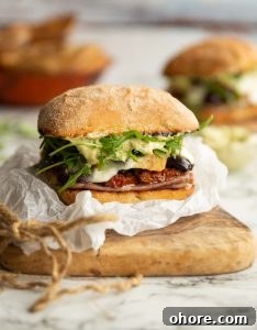 sandwich on crumpled parchment paper on wooden chopped board