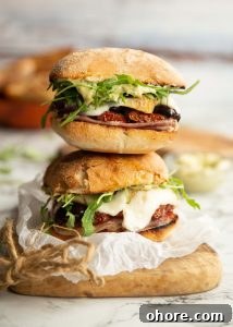 two sandwiches stacked on each other on wooden chopping board