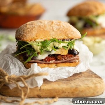 sandwich on crumpled parchment paper on wooden chopped board