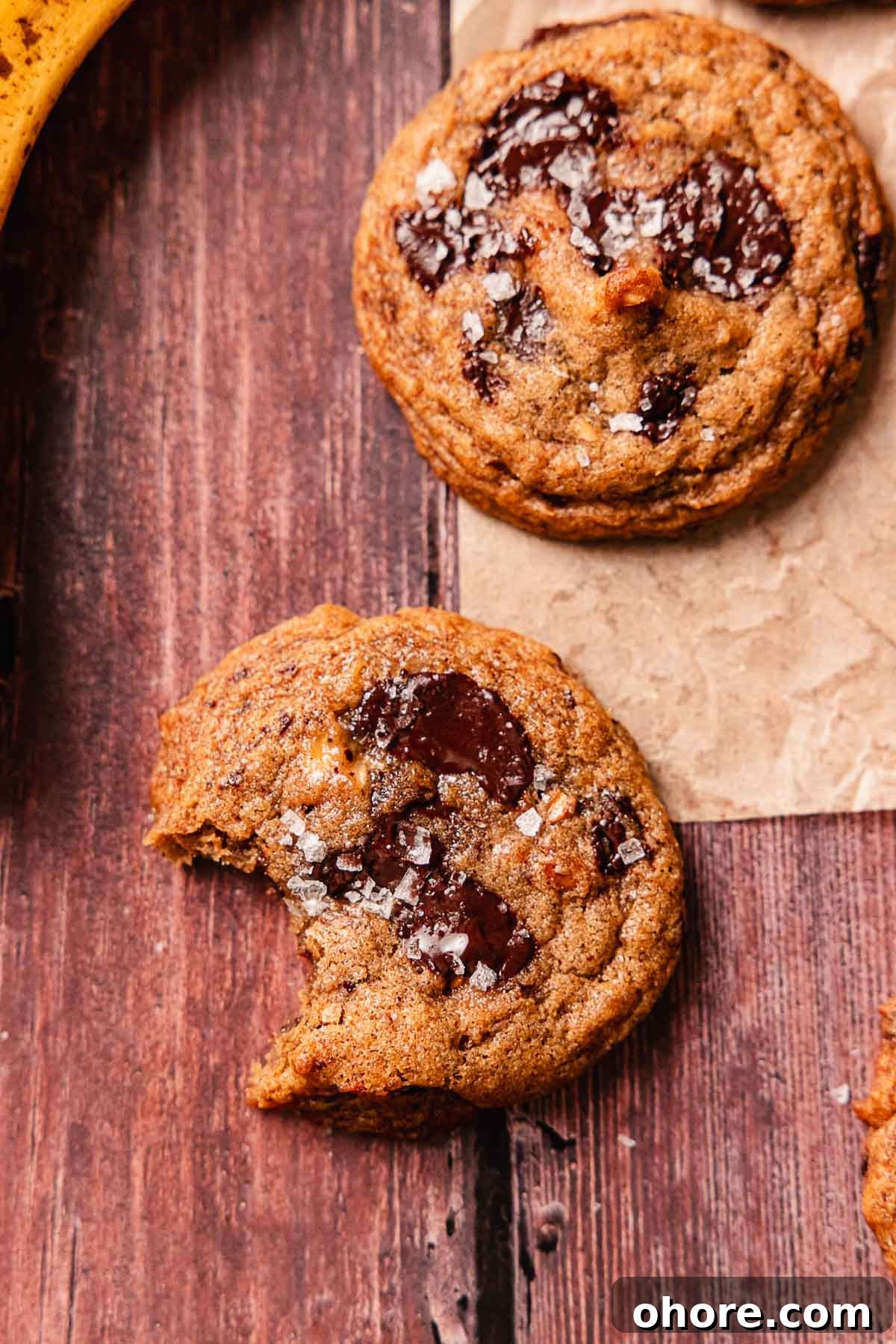 bitten crispy banana bread cookie on wooden table