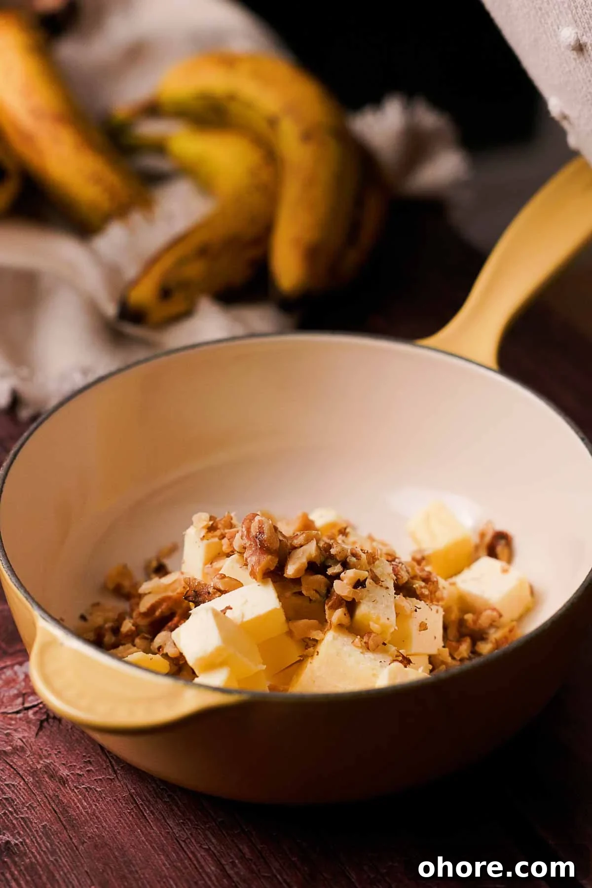 combining butter and chopped walnuts in a saucepan
