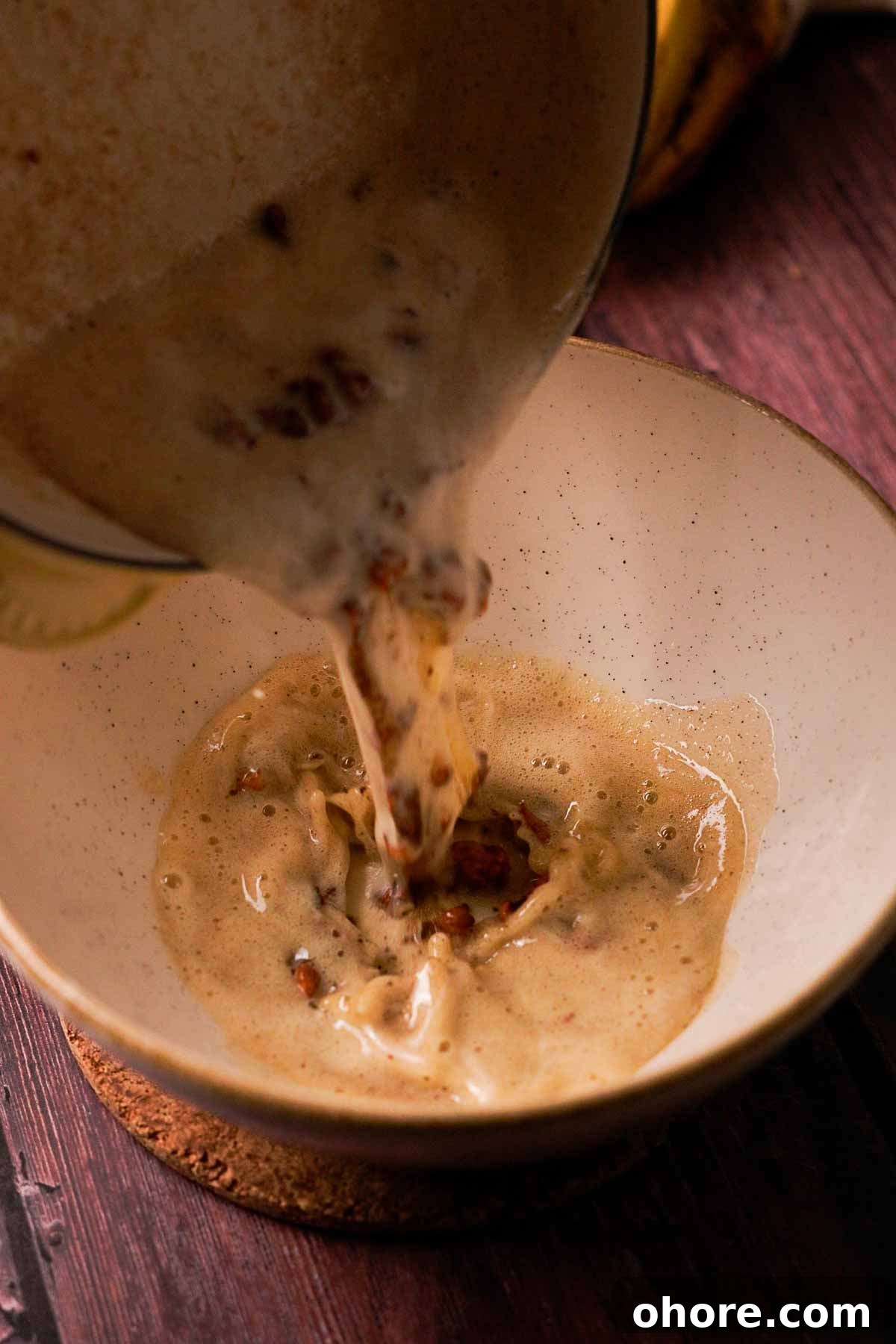 pouring brown butter and walnuts into bowl