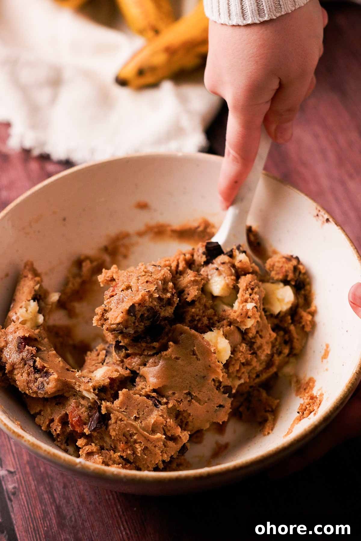 folding banana chunks and chocolate into cookie dough