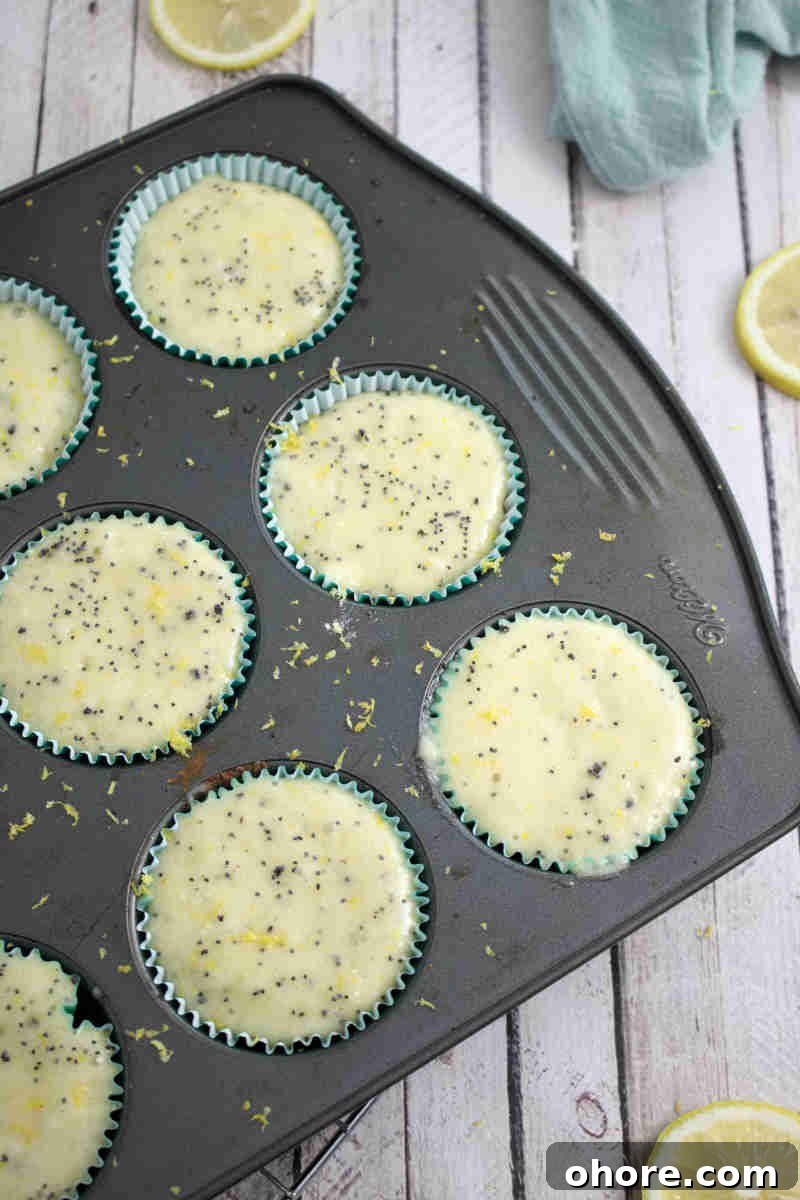 Raw gluten-free lemon muffin batter in a muffin tin.