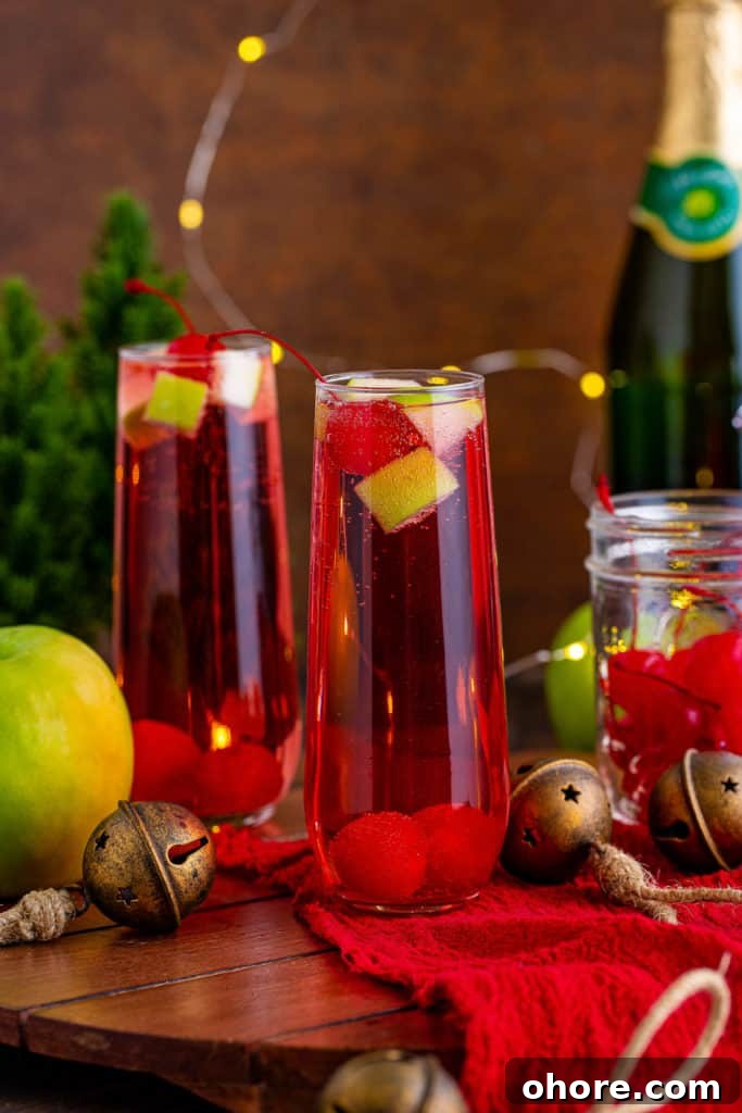 Sparkling Christmas Mocktail Recipes for Holiday Parties 2 Christmas mocktail on a board with apples and sparkling apple cider.