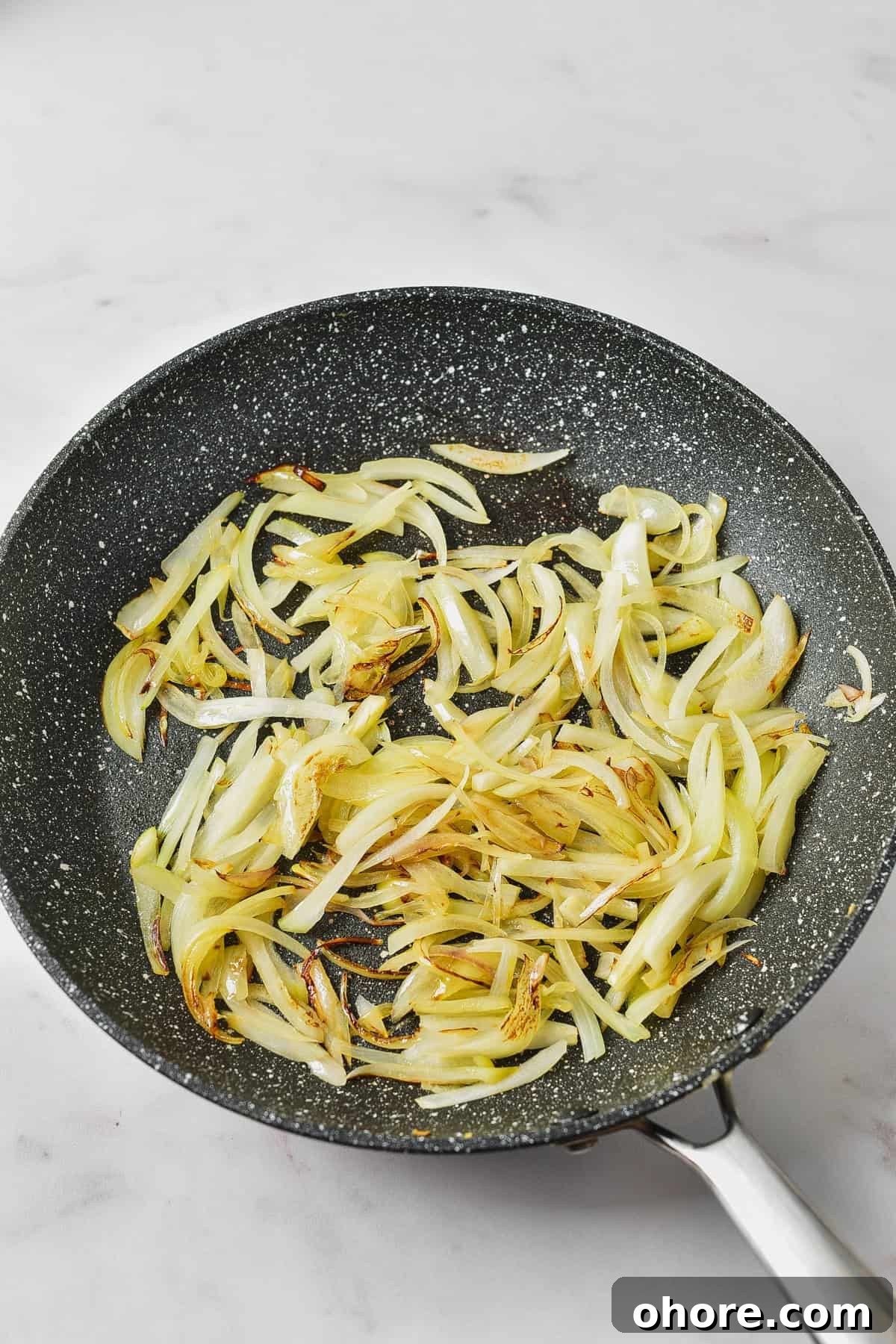 Authentic Chicken Tinga Recipe — Classic Tinga de Pollo 4 Cooking onions in a skillet.