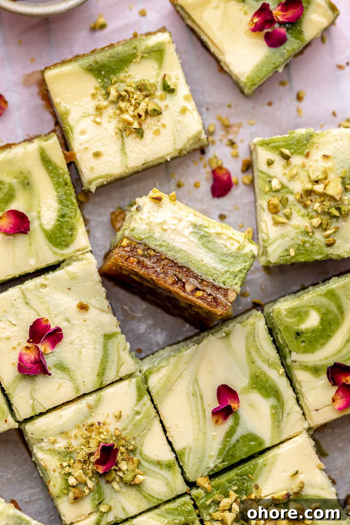 Sliced baklava cheesecake bars on parchment paper.