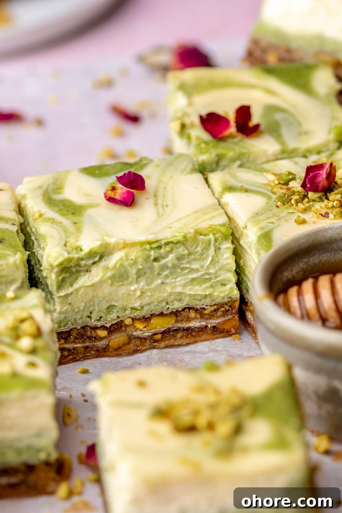 Sliced baklava cheesecake bars on parchment paper.