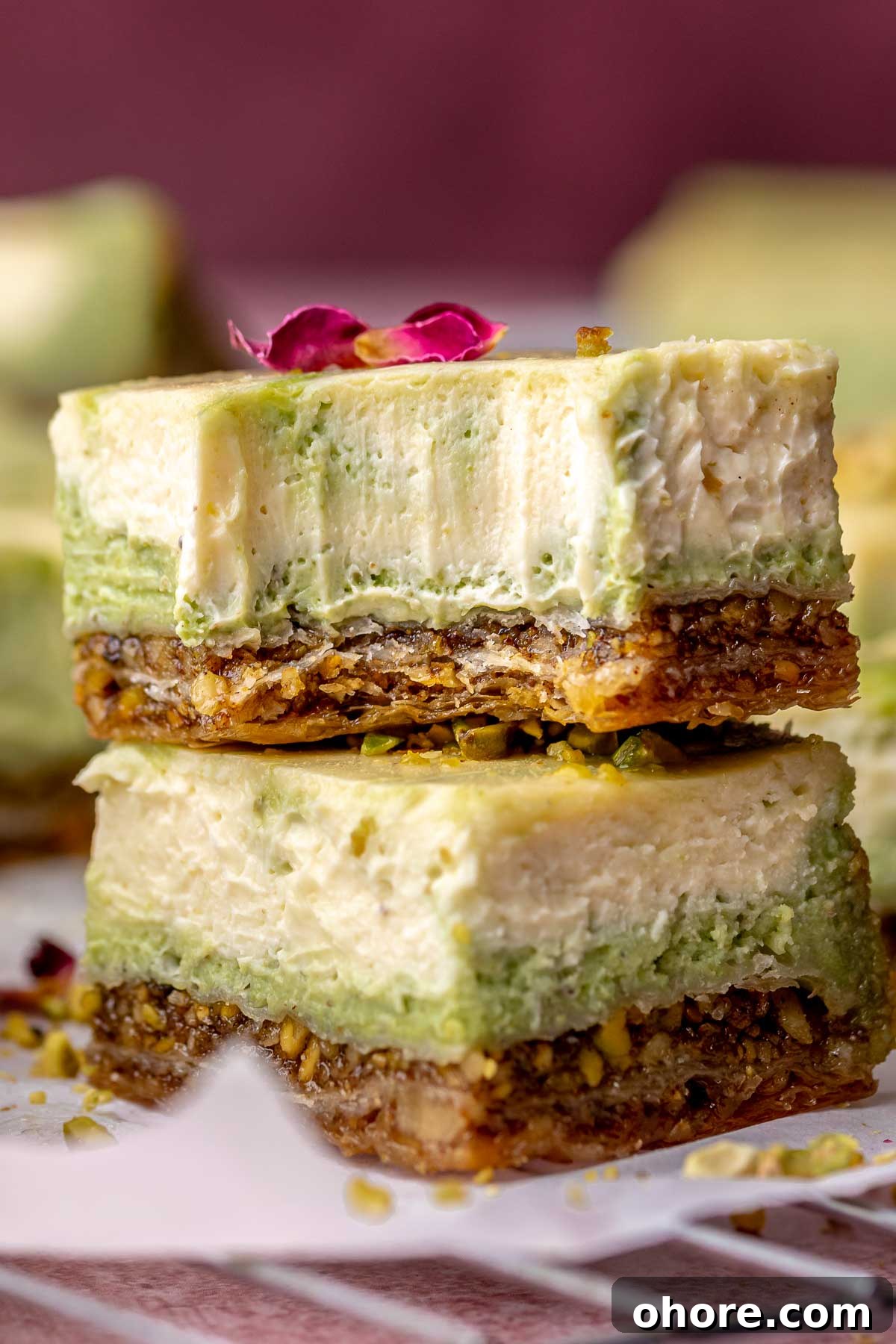 Stacked baklava cheesecake bars. The top bar has a bite removed.