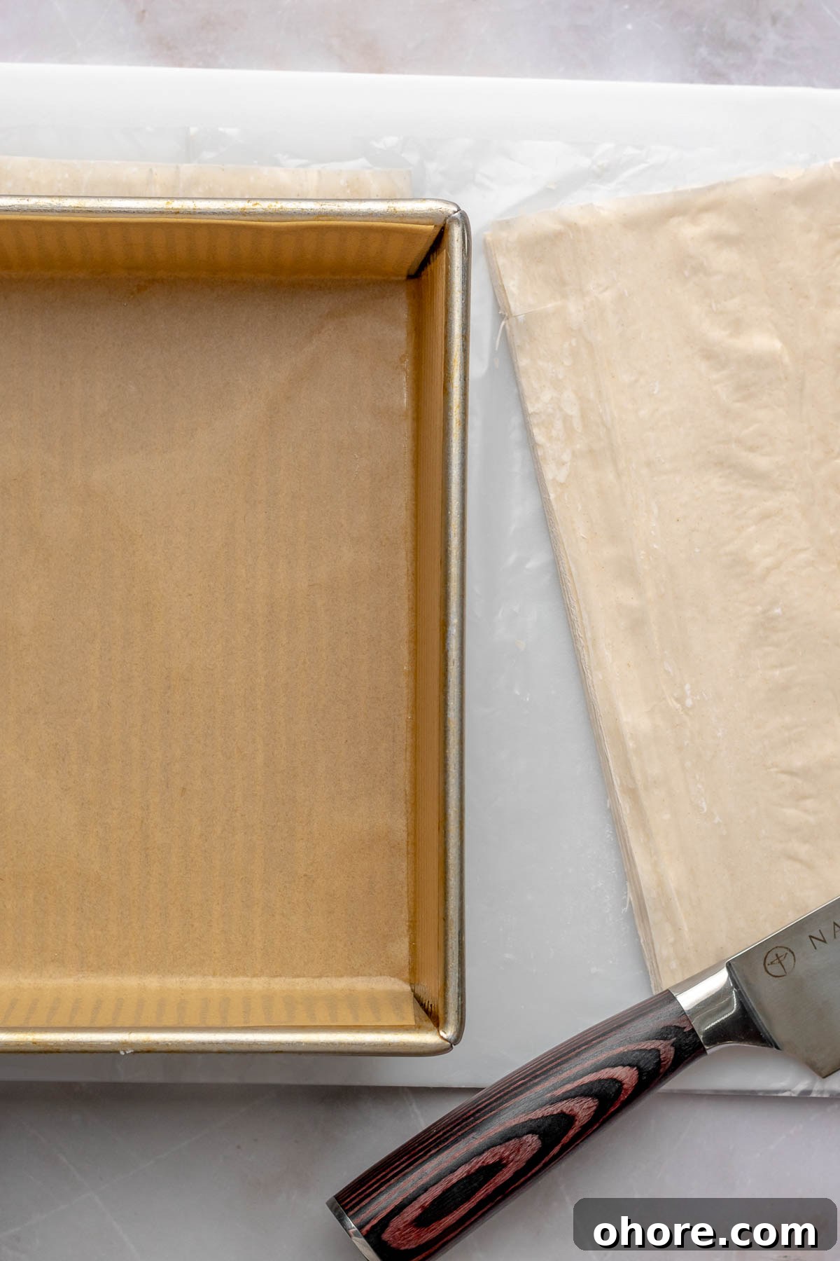 A pan, knife, and phyllo sheets.
