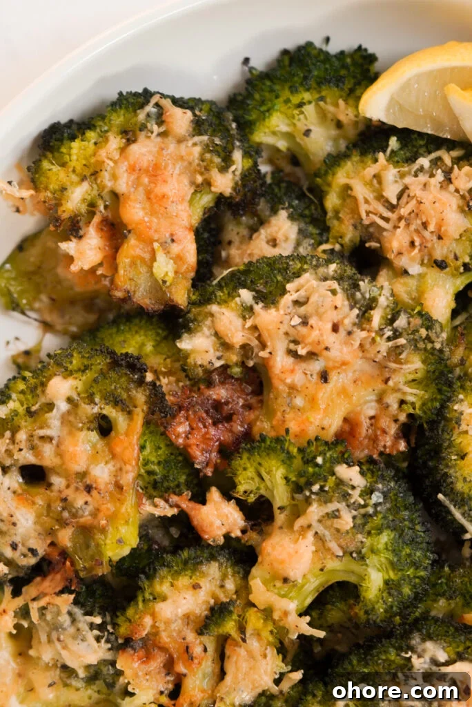 Crispy Smashed Broccoli with Parmesan and Garlic 17 smashed broccoli parmesan in a serving bowl with lemon wedges.