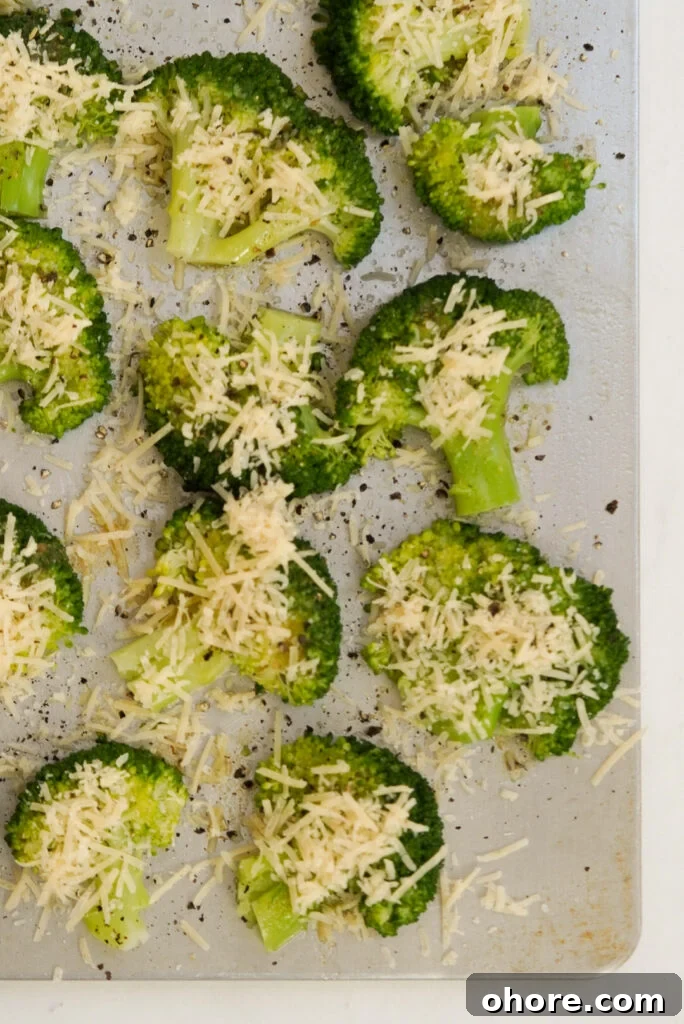 Crispy Smashed Broccoli with Parmesan and Garlic 10 smashed broccoli with parmesan cheese shreds on a baking sheet prior to baking.