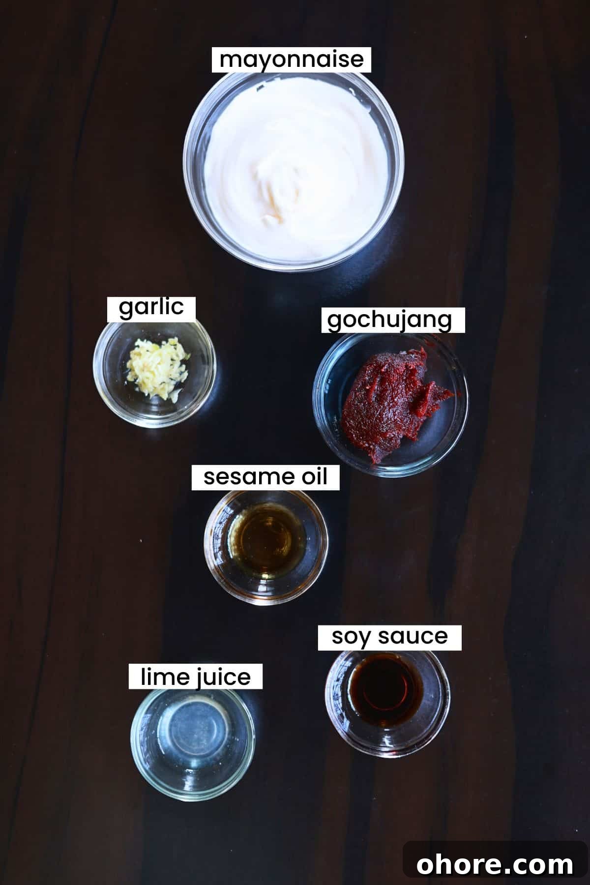 Gochujang aioli ingredients are placed on a dark background.
