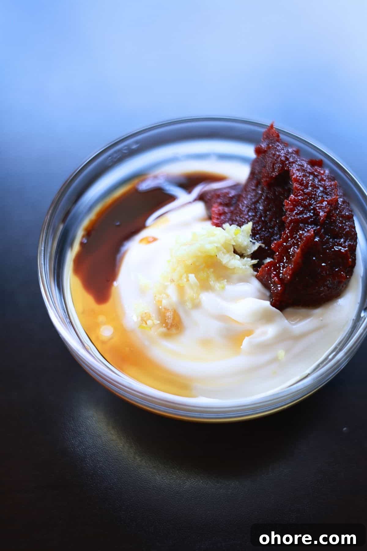 Image showing mixing gochujang, mayo, and other ingredients together in a bowl.