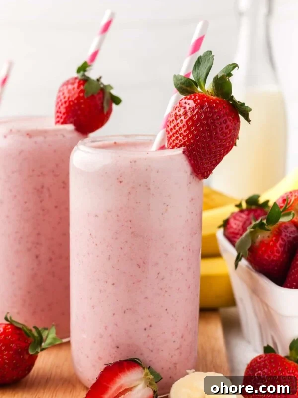 A strawberry banana smoothie garnished with a strawberry.