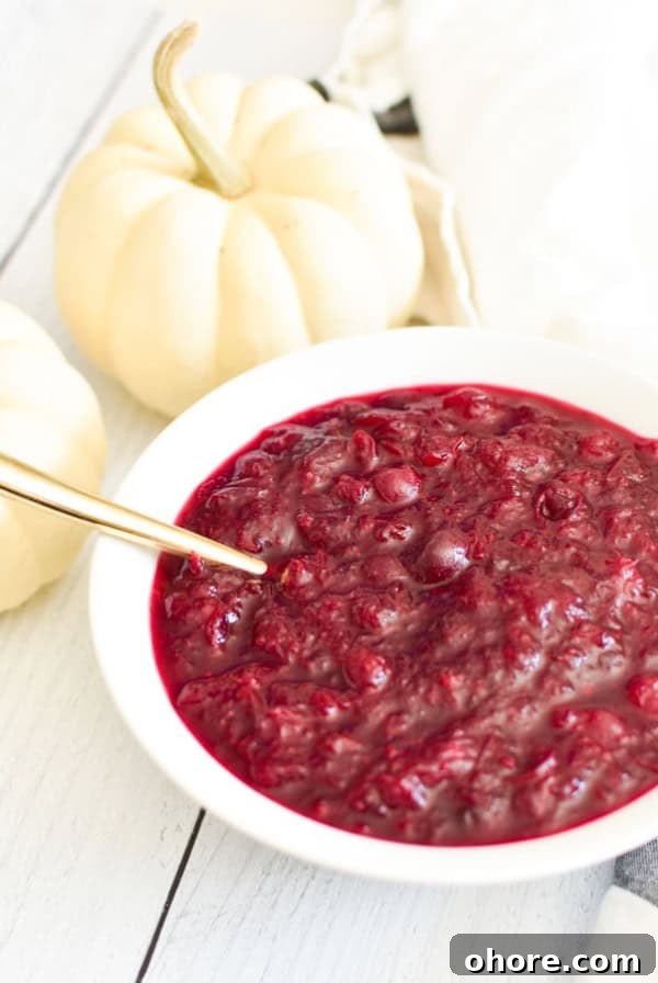 Cranberry sauce in a white bowl with white pumpkins in the background