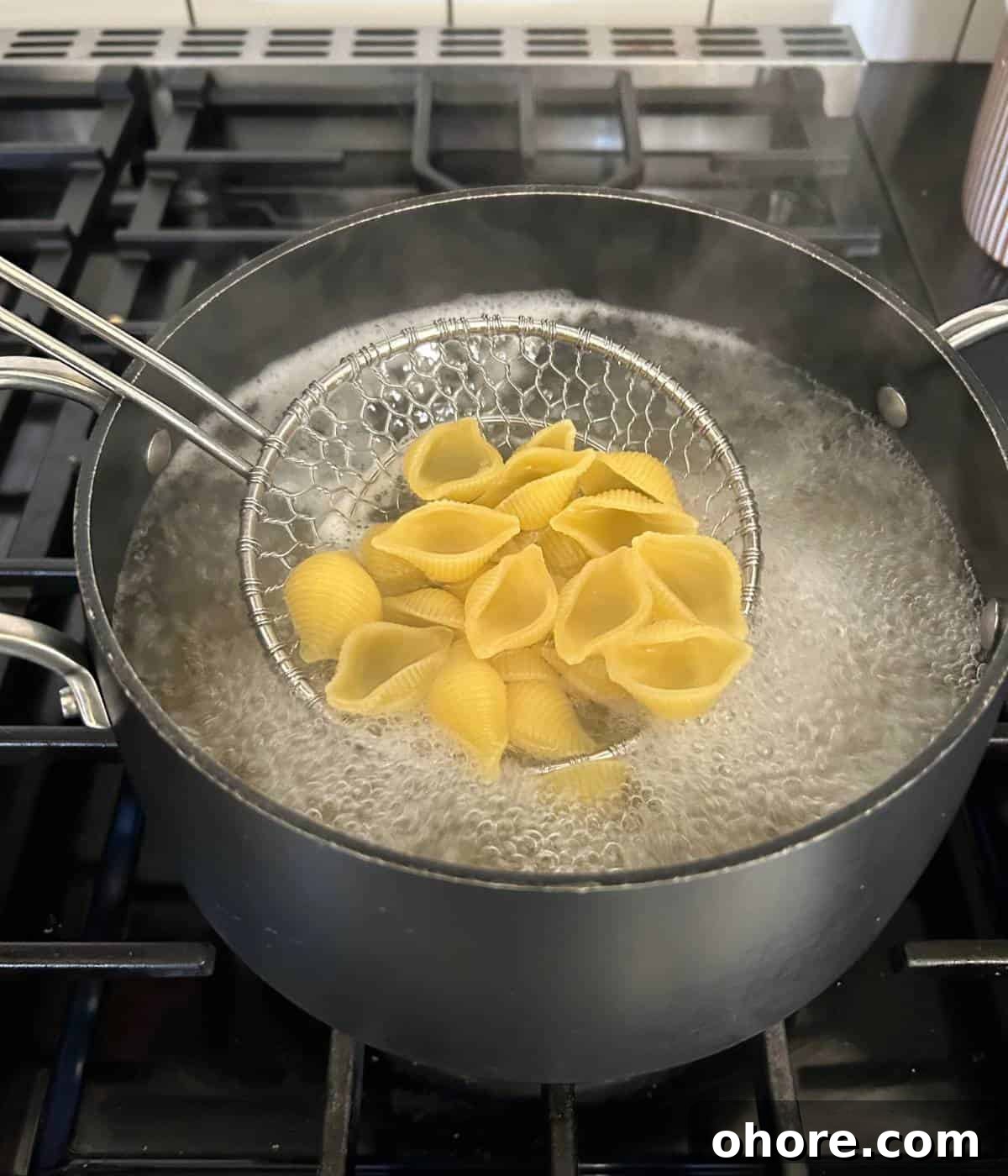 Cooking shell pasta in boiling water.