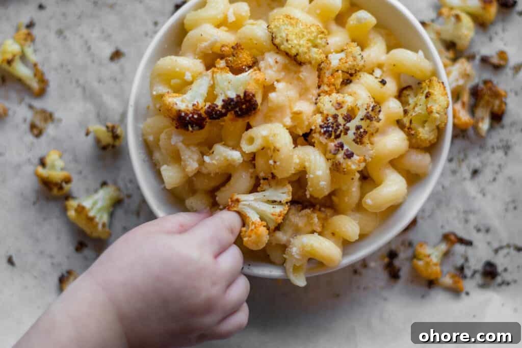 Roasted Cauliflower Mac and Cheese Casserole Recipe 3 little kids hand reaching for cauliflower from bowl of mac 'n cheese
