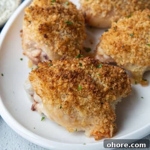 breadcrumb topped ranch chicken thighs on a white platter.