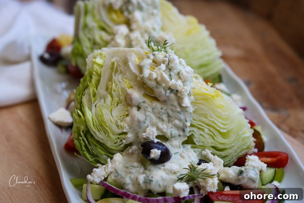 Greek Wedge Salad with Creamy Yogurt Dill Dressing 3 wedge salad with toppings on white plate with napkin