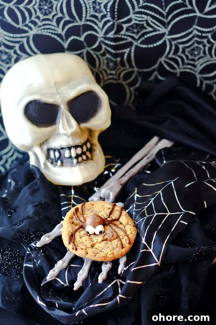 Malted Milk Ball Spider Cookies for Halloween Party Treats 5 One malted milk ball spider cookie with a chocolate bodied spider on a skeleton hand with a skull.