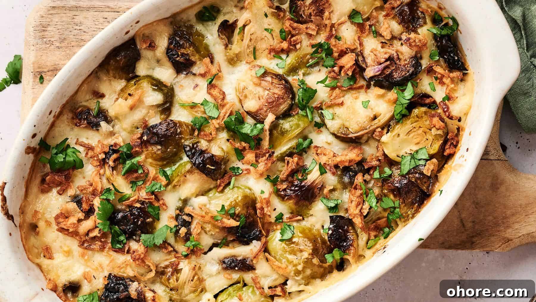 29 Cozy Air Fryer Casseroles for Warm January Dinners 20 A baked casserole dish filled with roasted Brussels sprouts, melted cheese, crispy onions, and chopped herbs on top.
