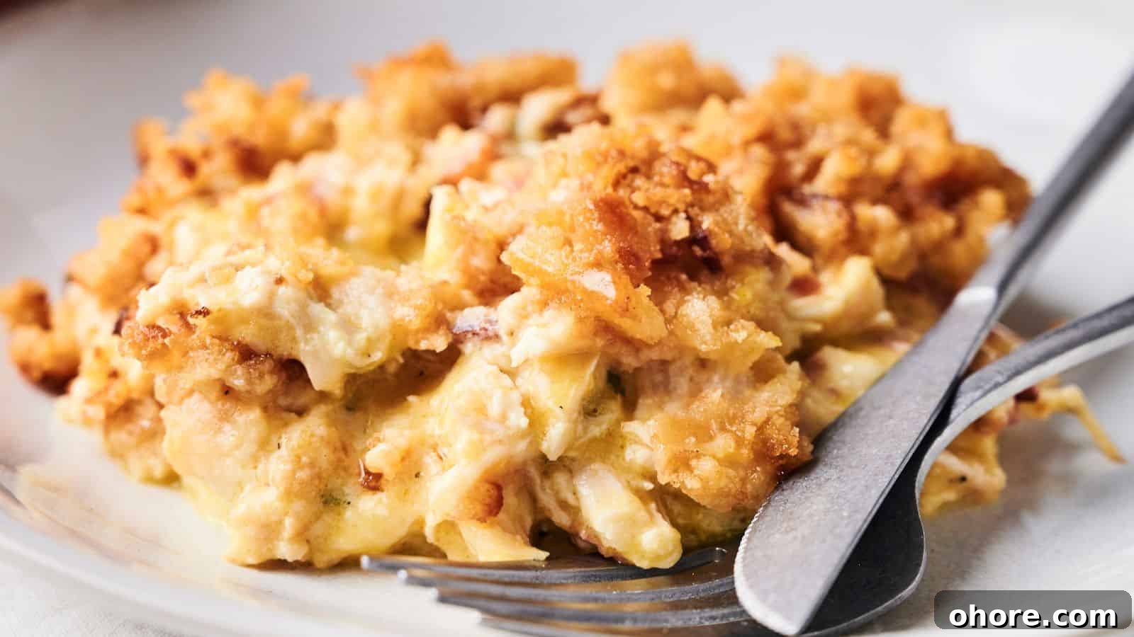 29 Cozy Air Fryer Casseroles for Warm January Dinners 21 A plate of creamy macaroni and cheese topped with a crispy breadcrumb crust, with a fork and knife resting on the plate.