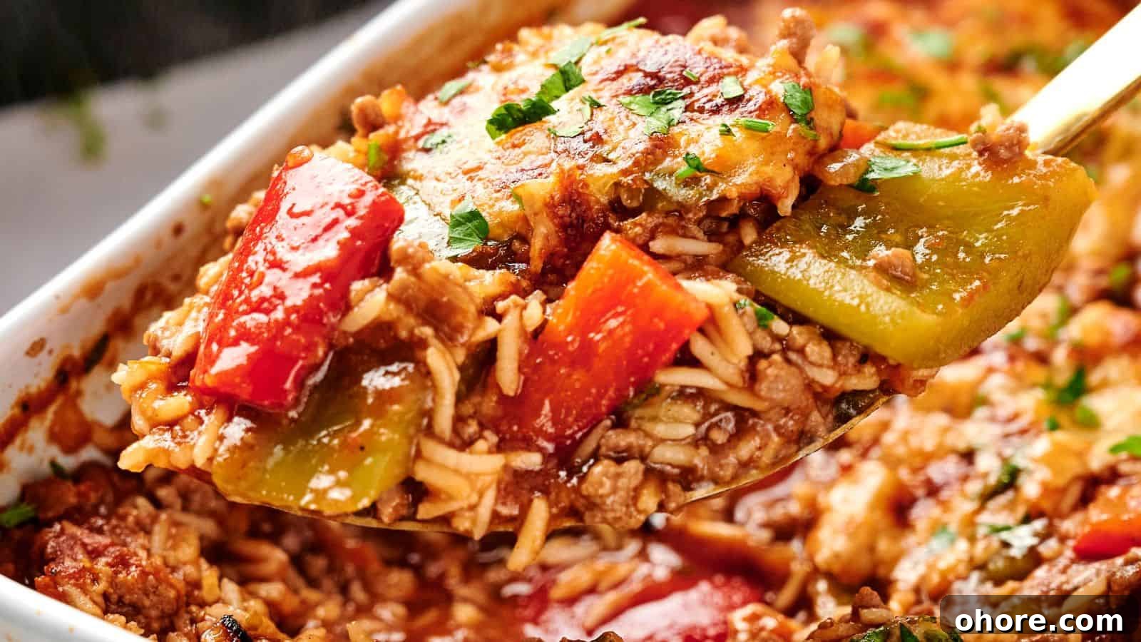 29 Cozy Air Fryer Casseroles for Warm January Dinners 27 A spoonful of baked stuffed pepper casserole with ground meat, rice, and diced red and green bell peppers, garnished with parsley.