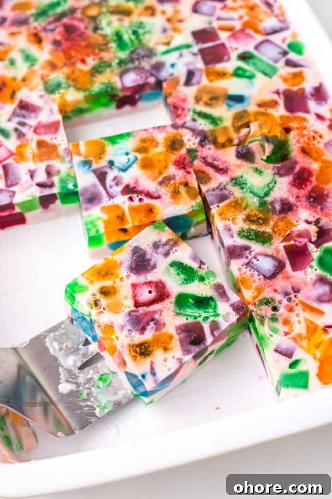 Retro Broken Glass Jello Recipe – Colorful Layered Dessert 9 Sliced Broken Glass Jello dessert squares showing colorful gelatin cubes in creamy milk gelatin