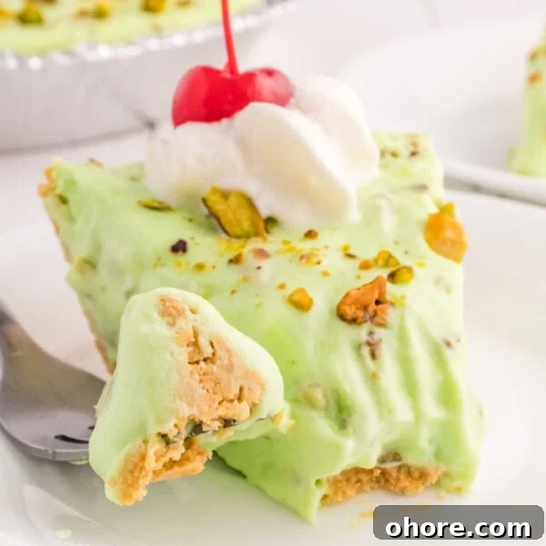 Retro Broken Glass Jello Recipe – Colorful Layered Dessert 11 square image of pistachio cream pie slice with whipped cream and cherry on top