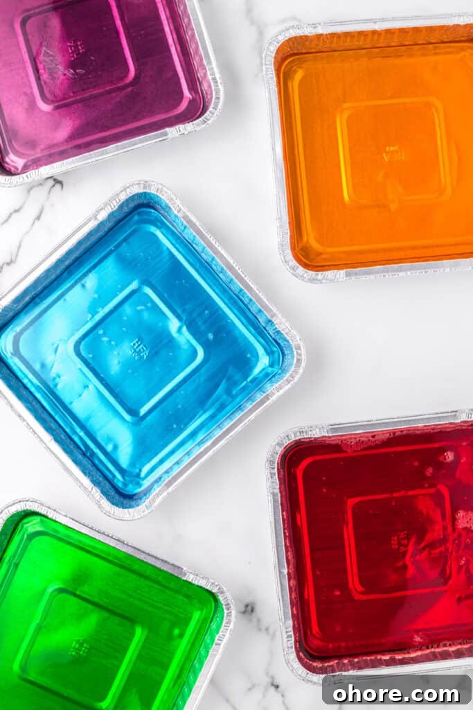 Retro Broken Glass Jello Recipe – Colorful Layered Dessert 5 Colorful flavored gelatin setting in foil pans for Broken Glass Jello recipe
