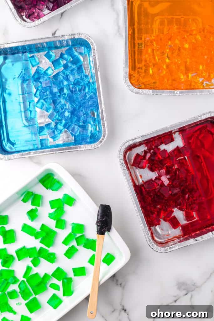 Retro Broken Glass Jello Recipe – Colorful Layered Dessert 6 Cubed gelatin pieces for Broken Glass Jello recipe arranged in foil pans and baking dish