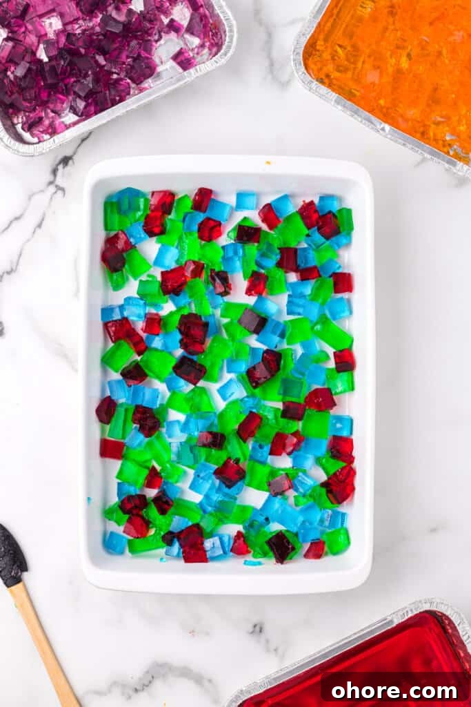 Retro Broken Glass Jello Recipe – Colorful Layered Dessert 7 Colorful Jello cubes layered in baking dish for Broken Glass Jello dessert
