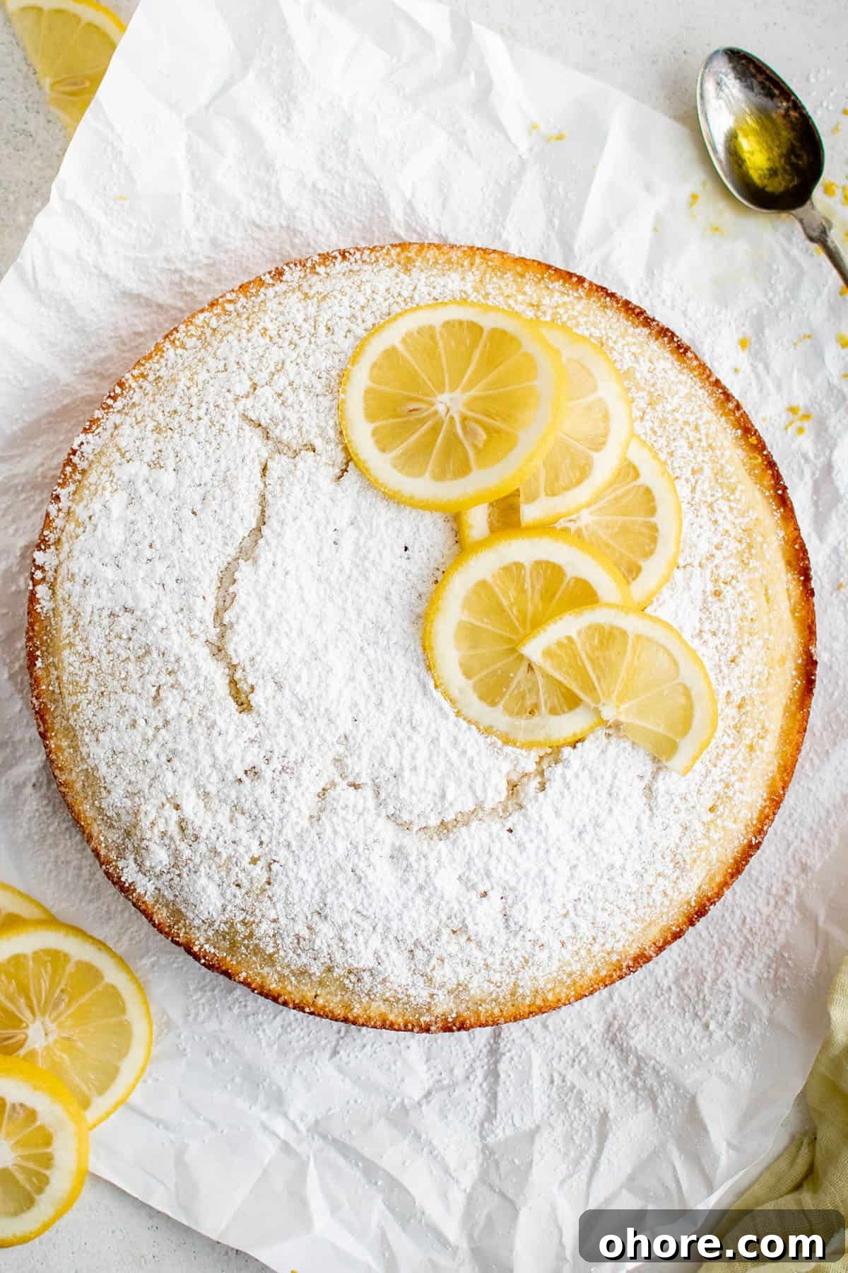 Moist Olive Oil Cake Recipe with Lemon Glaze 4 picture of olive oil cake with powdered sugar and slices of lemon