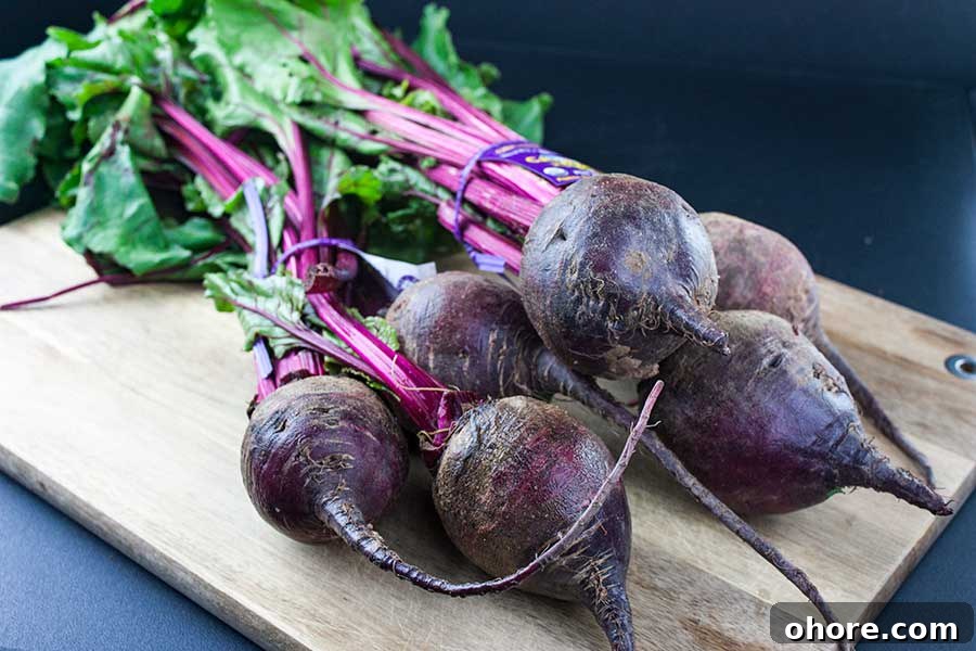 Ninja Foodi Pressure Cooker Fresh Beets - Fresh beets in 30 minutes! So flavorful, tender and healthy! A beautiful colorful side dish to any meal. Fresh beets with greens attached on a wooden cutting board.