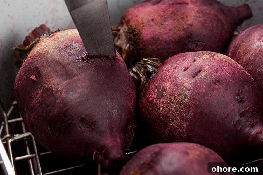 Ninja Foodi Pressure Cooker Fresh Beets - Fresh beets in 30 minutes! So flavorful, tender and healthy! A beautiful colorful side dish to any meal. Cooked beets being tested with the tip of a knife for tenderness.
