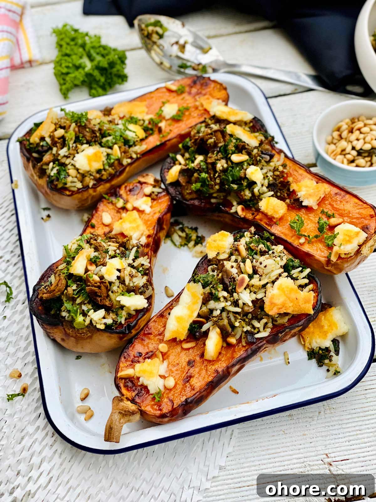 Roasted Curried Butternut Squash Recipe with Crispy Edges 3 Roasted curried butternut squash on a white tray sprinkled with halloumi cheese and fresh herbs