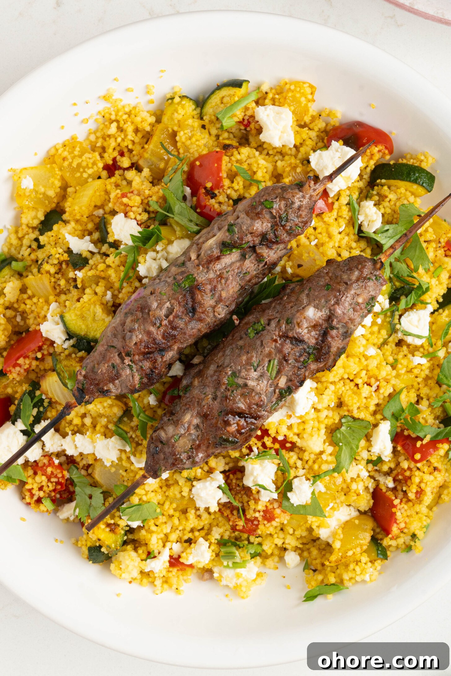 30-Minute Moroccan Kefta Brochettes Recipe — Grilled Lamb Skewers 11 kefta on a plate of couscous salad