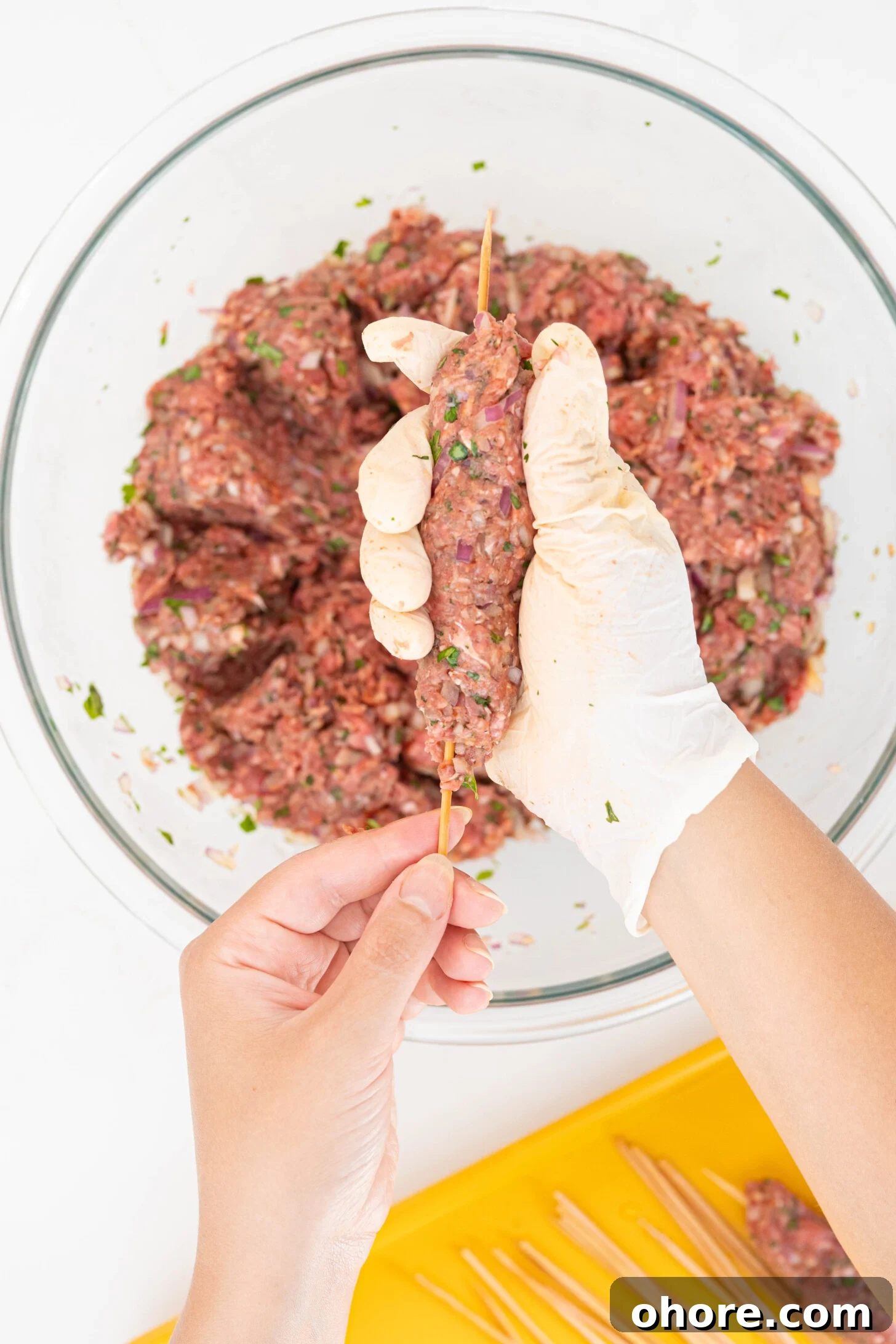 30-Minute Moroccan Kefta Brochettes Recipe — Grilled Lamb Skewers 6 hands forming kefta around skewers