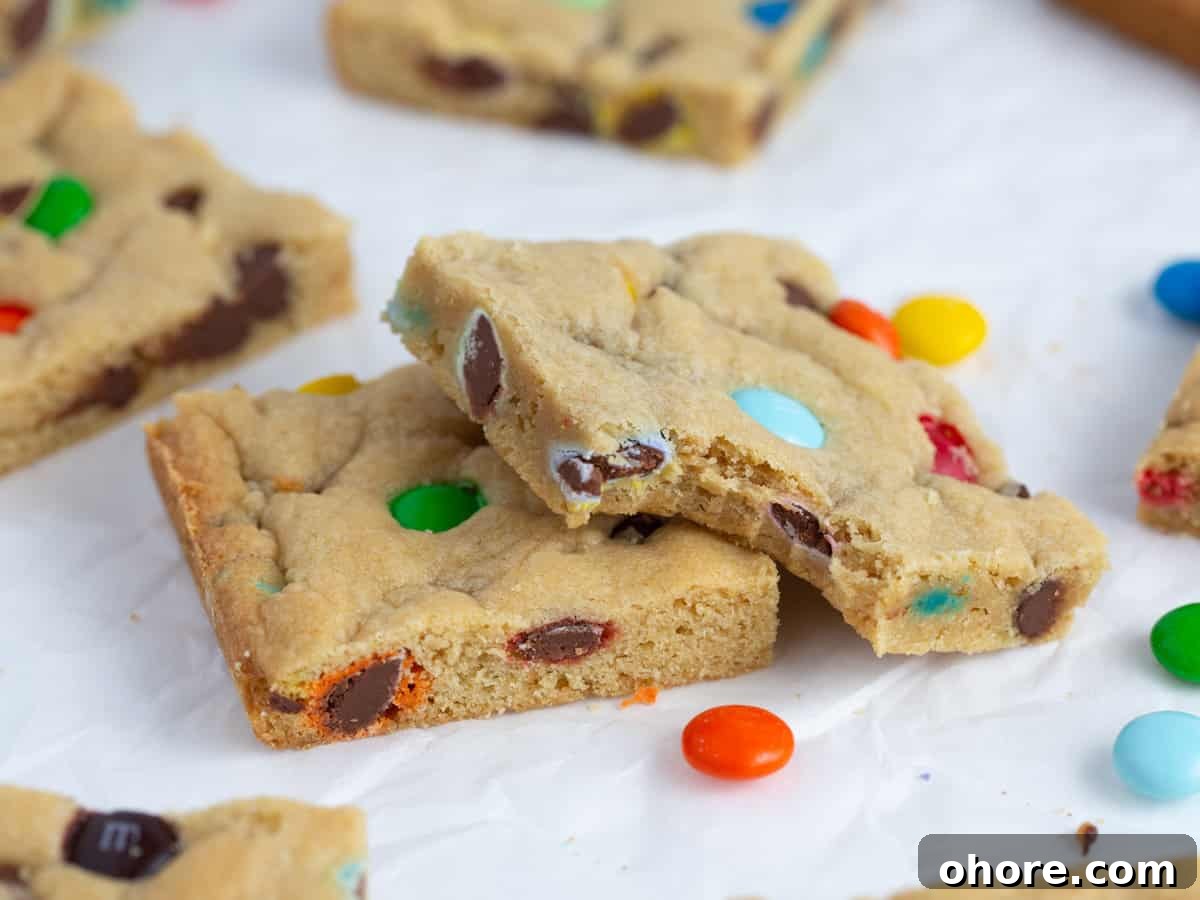 Chewy M&M Cookie Bars Recipe — Loaded Candy Cookie Bars 3 Chewy M&M Cookie bar squares with bite