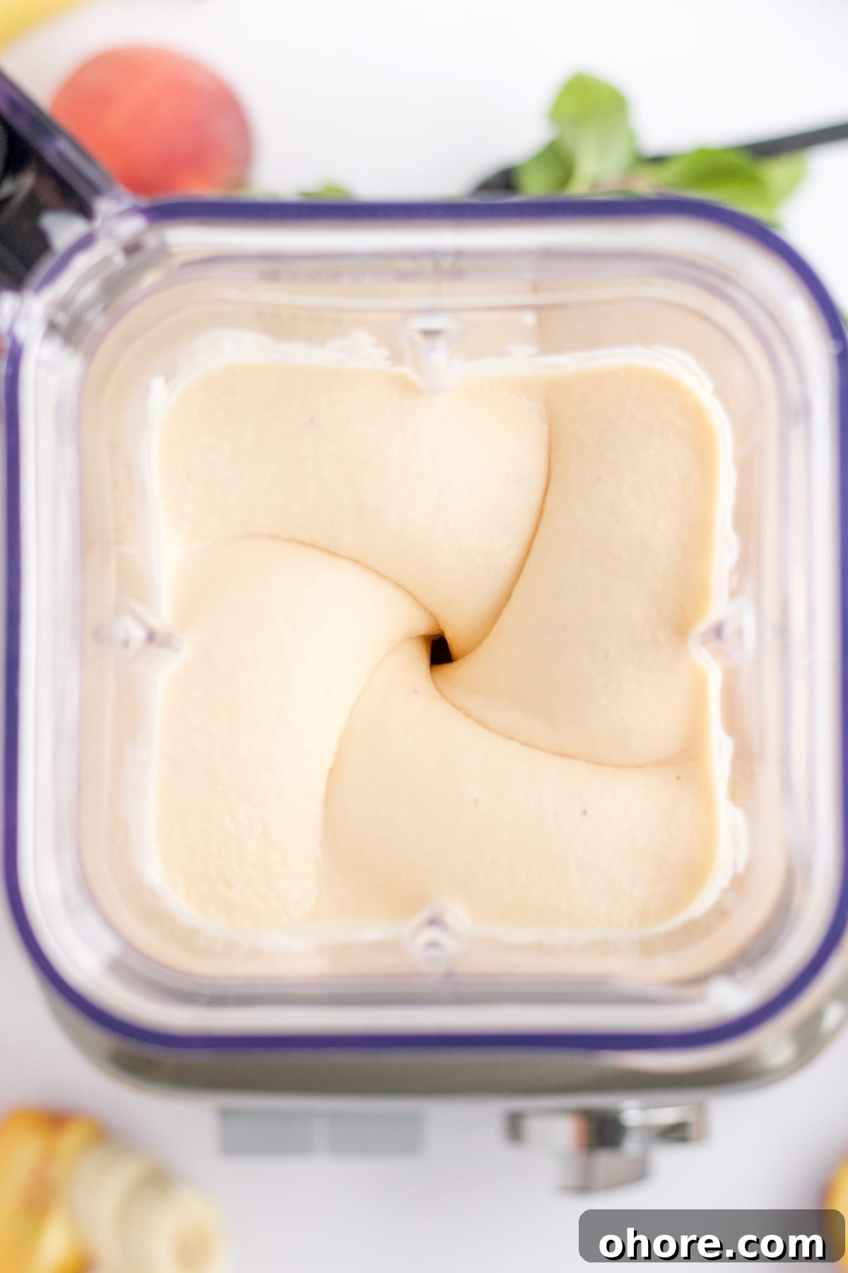 Peach smoothie ingredients that are being blended until smooth