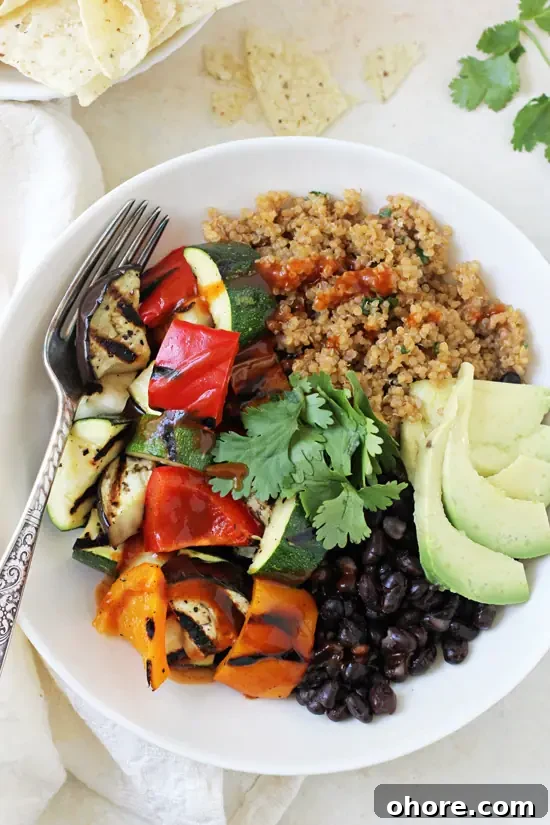 These light & fresh grilled vegetable enchilada bowls are a fantastic summer meal! With a flavorful quinoa pilaf, grilled veggies and plenty of toppings! An overhead view of a Grilled Vegetable Enchilada Bowl with tortilla chips to the side.