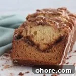 sliced cinnamon swirl quick bread with seafoam green towel alongside.