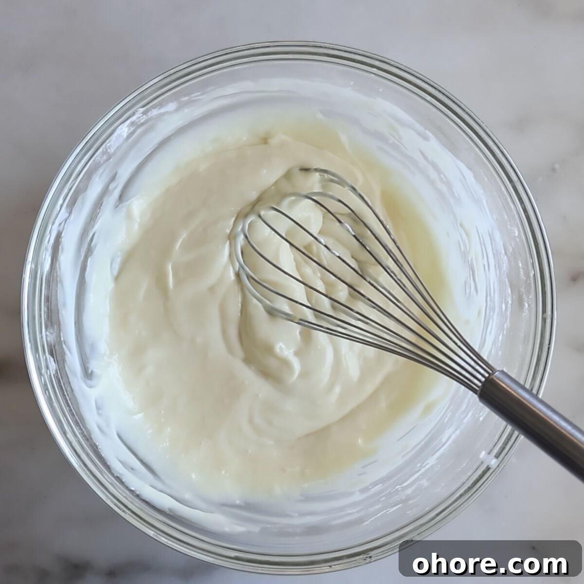 whisking batter together in a large glass bowl.