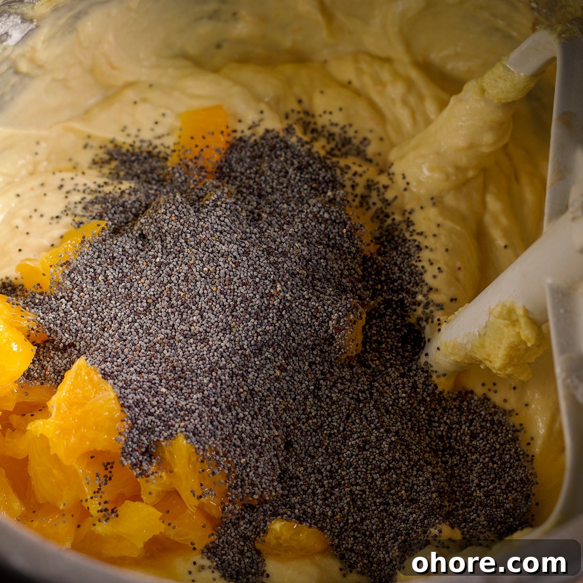 Orange Poppy Seed Cake with Mascarpone Frosting Recipe 15 Adding orange pieces and poppy seeds to the cake batter.
