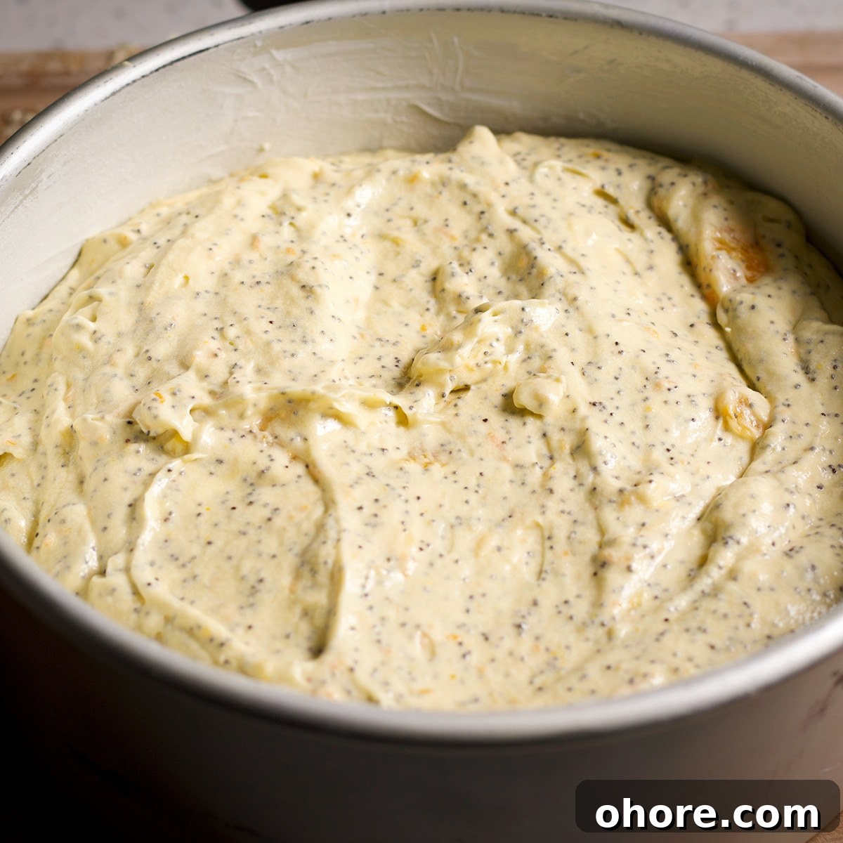 Orange Poppy Seed Cake with Mascarpone Frosting Recipe 16 An 8-inch round cake pan filled with orange poppy seed cake batter.