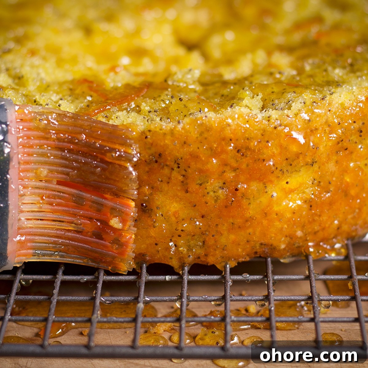 Orange Poppy Seed Cake with Mascarpone Frosting Recipe 18 Using a pastry brush to cover an orange poppy seed cake with an orange glaze.