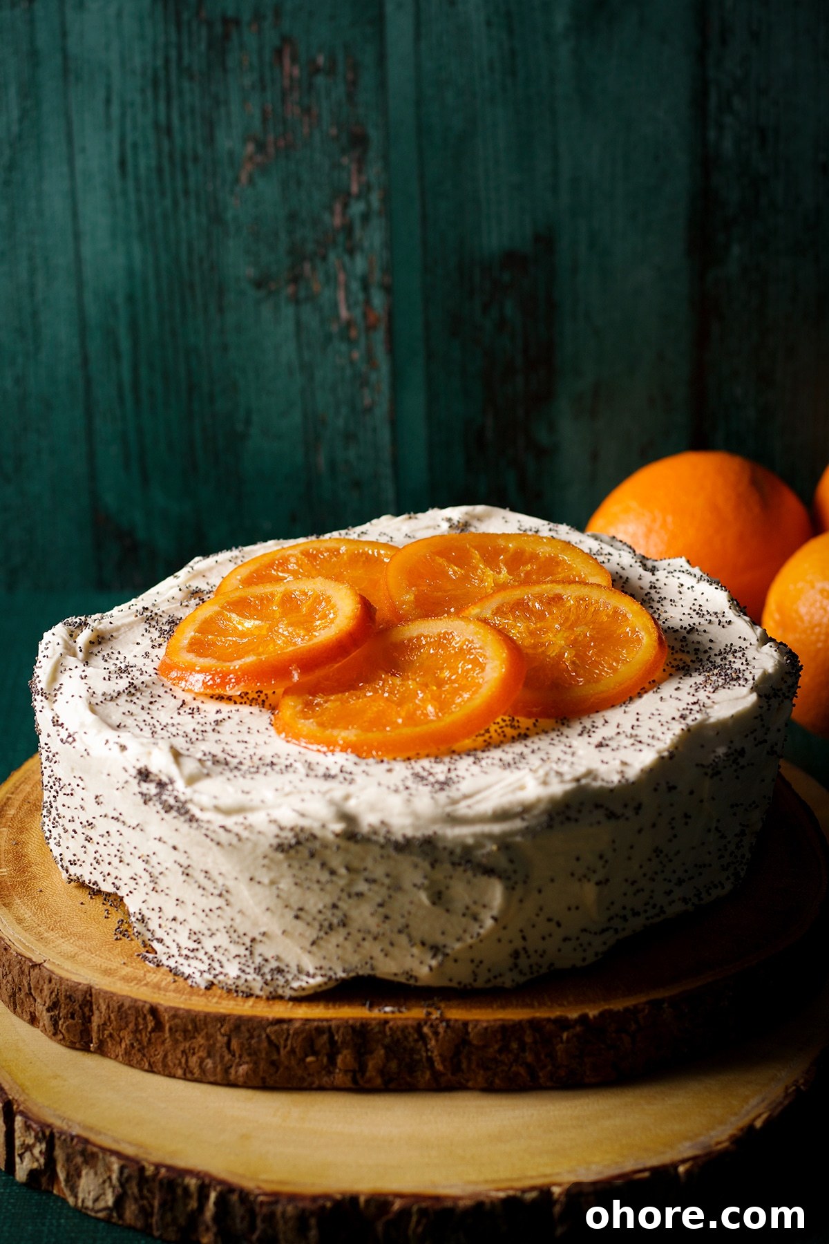 Orange Poppy Seed Cake with Mascarpone Frosting Recipe 19 An orange poppy seed cake covered in mascarpone frosting, sprinkled with poppy seeds, and decorated with candied oranges.