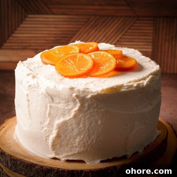 An orange olive oil cake covered in mascarpone frosting and decorated with candied oranges.