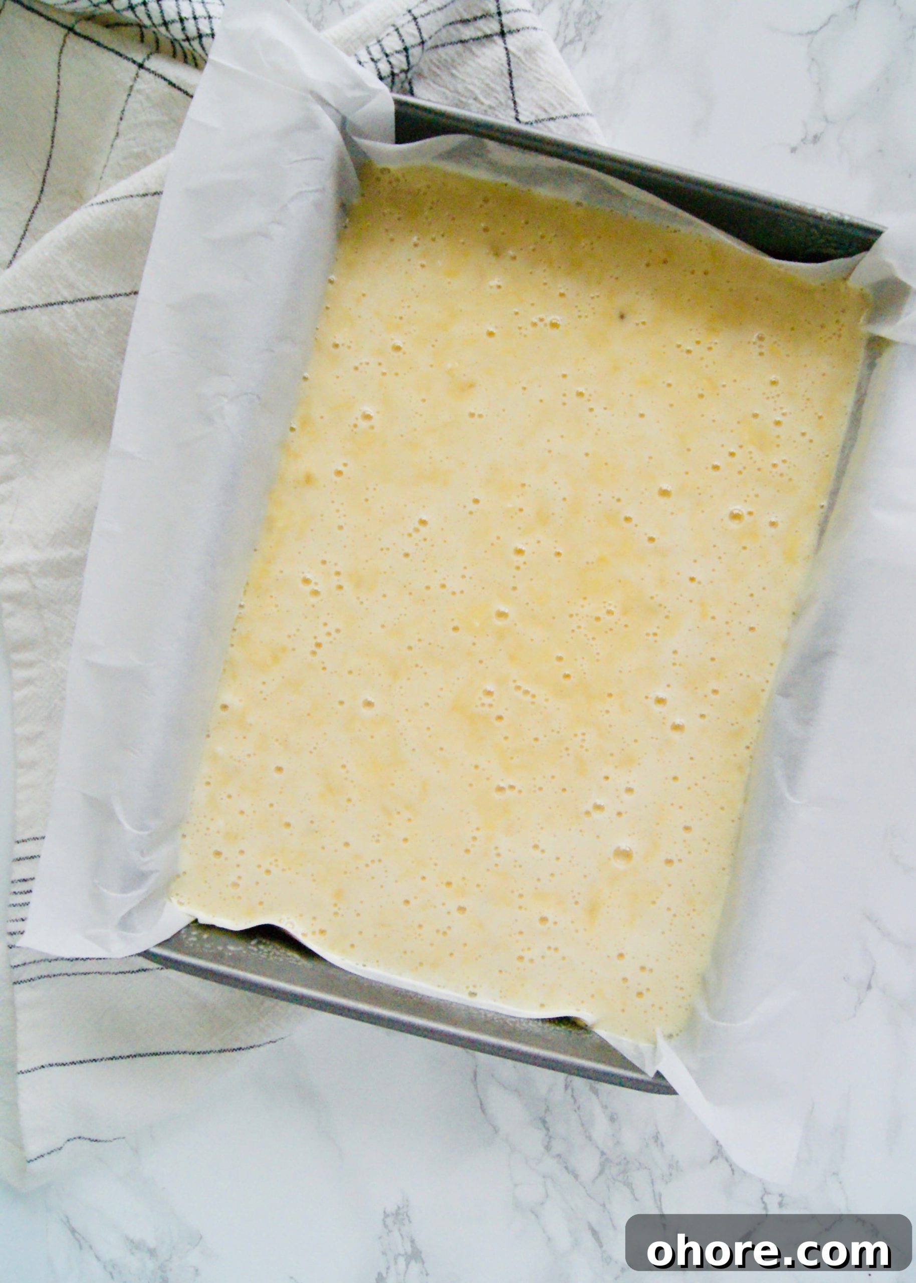 Unbaked pineapple cake batter in a cake pan
